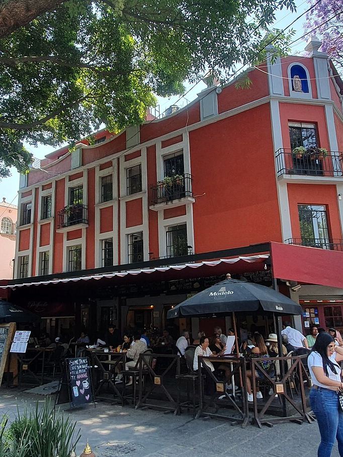 Un edificio colonial rojo y cafés en el centro de Coyoacán